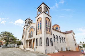 A church with a bell tower, arched windows, and a dome. - Dashing Dome - A Sepal Stay (Perth)