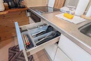 A kitchen with a built-in dishwasher, a coffee maker, and a paper towel dispenser on the countertop. - Bella yui Miyakojima 2 (Higashinakasone,Hirara,Miyakojima)