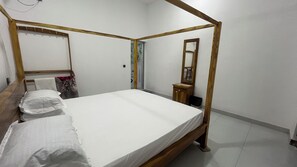 A four-poster bed with a wooden frame, a bedside table, a mirror, and a wall-mounted shelf. - Salt & sand resort (Arugam Bay)