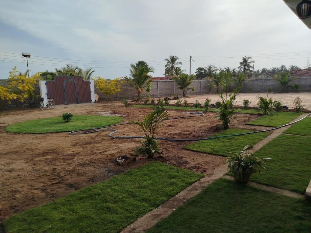 A landscaped outdoor area with a paved path, a small garden, and a gated entrance.