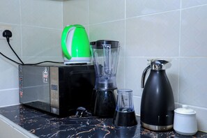 En køkkenbordplade med kaffemaskine, blender og elkedel.