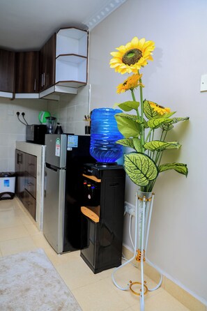 Eine Küche mit Wasserspender, Kühlschrank und einer Blumenvase.