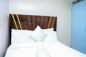 Ein Bett mit Kopfteil, Kissen und Decke.