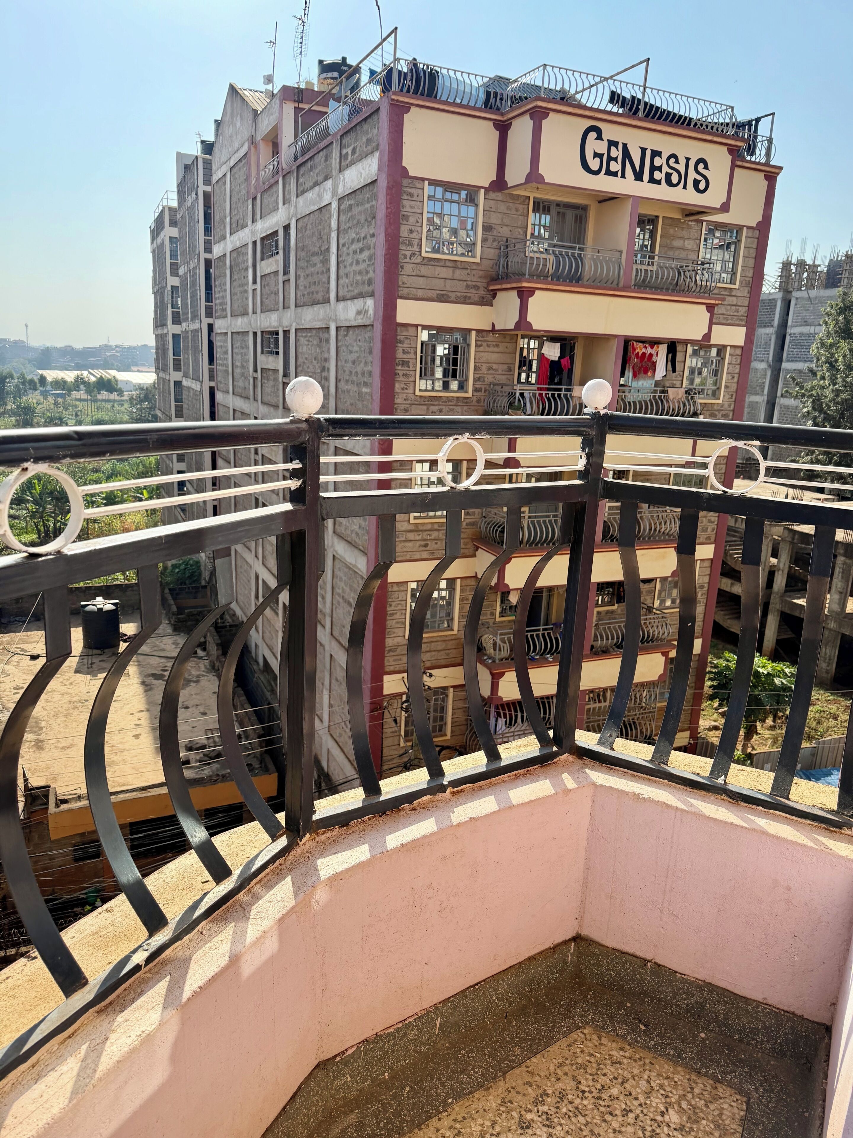 Ein mehrstöckiges Gebäude mit einem Balkon und einem Schild mit der Aufschrift 'GENESIS'.