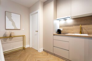 Eine moderne Küche mit Holzdielen im Fischgrätmuster, einer weißen Tür und einem minimalistischen Design.