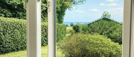 A window with a view of a garden and a house.