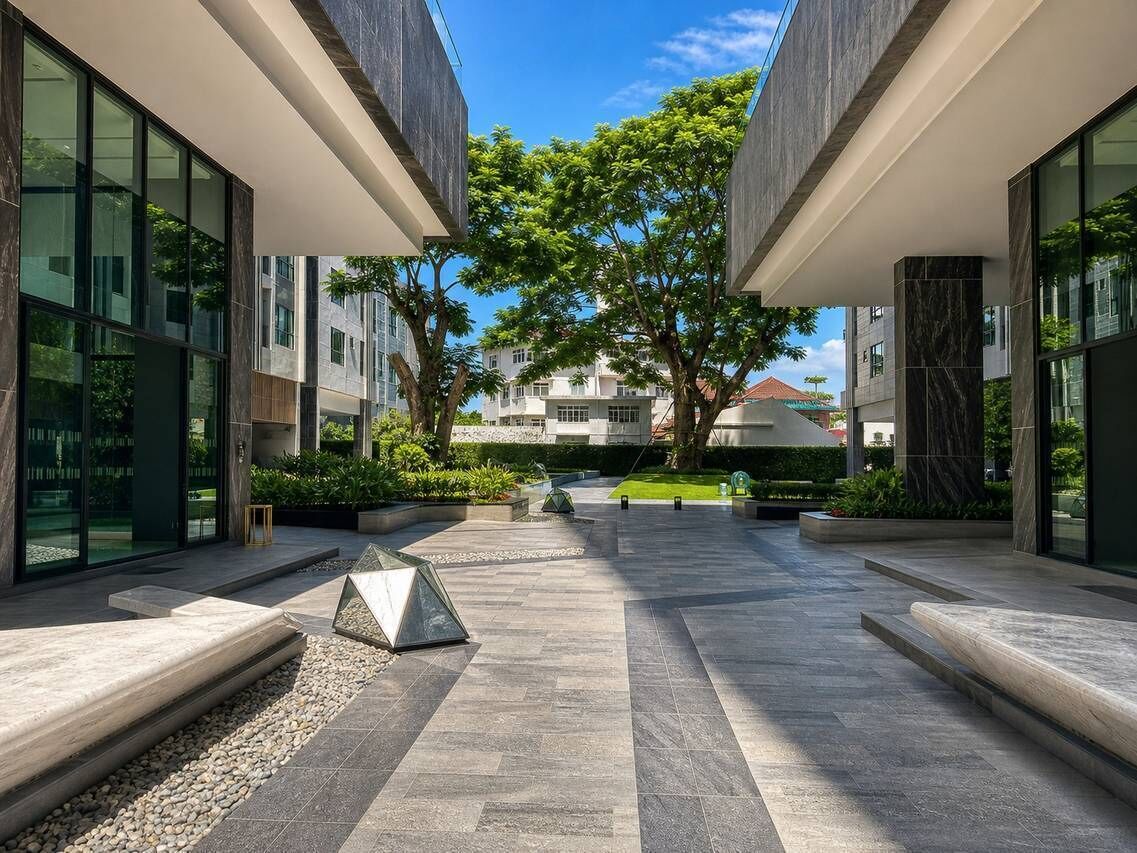 A modern building with a courtyard, large windows, and a tree.
