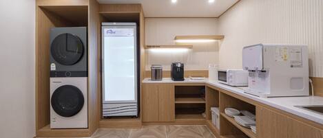A modern kitchen with built-in appliances, a coffee machine, and a microwave.