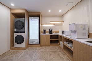 A modern kitchen with built-in appliances, a coffee machine, and a microwave.