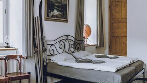 Un dormitorio con una cama, un armario de madera, un globo terráqueo y un cuadro en la pared.