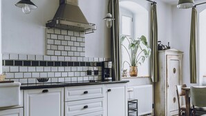 A kitchen with white cabinets, a black countertop, a coffee maker, and a potted plant. - Holiday Homes with Sokolik Mountain Views (Janowice Wielkie)