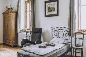 A room with a bed, a wooden cabinet, a chair, and a framed picture on the wall. - Countryside Stay in Trzcinsko (Janowice Wielkie)