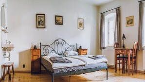 A bedroom with a metal bed frame, wooden nightstands, a desk with a chair, and a window with curtains. - Nature Retreat near Janowice (Janowice Wielkie)