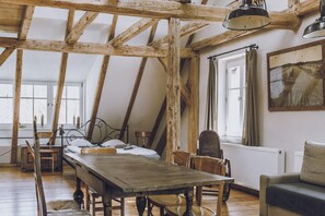 Ein rustikaler Raum mit freiliegenden Holzbalken, einem Bett, einem Tisch und einem Stuhl.