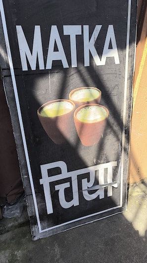 A sign with the word 'MATKA' and a picture of three cups, likely indicating a place serving matka.