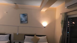 A hotel room with two beds, a wall-mounted light, and a ceiling fan. - Golden Barahi Retreat (Pokhara)