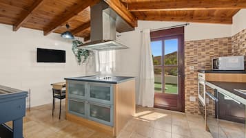 Una cocina moderna con una isla central, horno empotrado y microondas.
