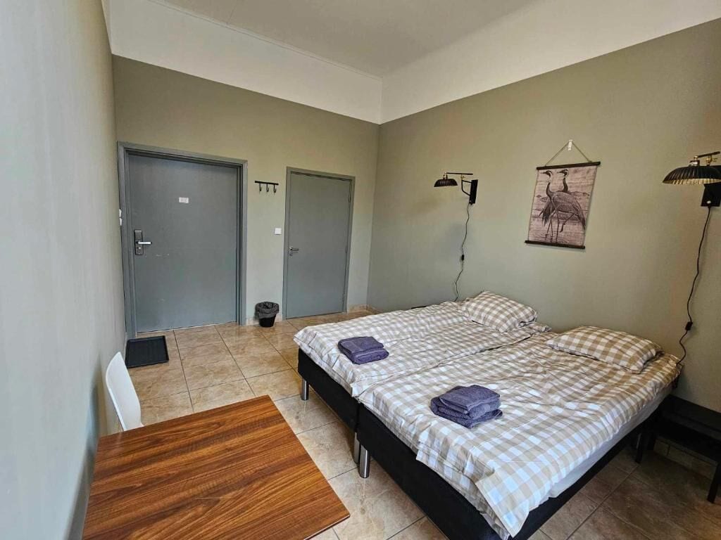 Une chambre à coucher avec un lit, un bureau et deux portes.