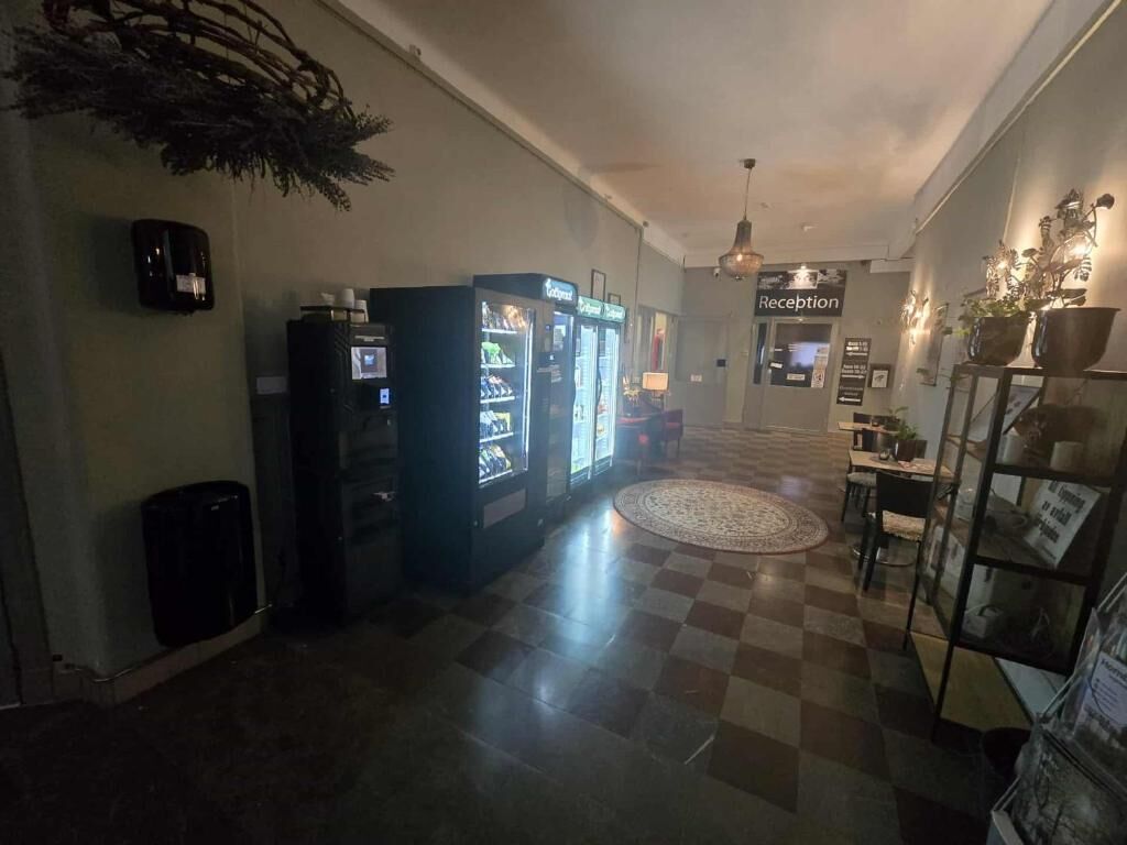 A hotel lobby with vending machines, a reception desk, and a check-in counter.