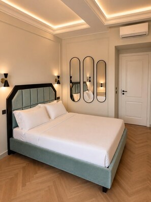 A modern bedroom with a bed, wall-mounted mirrors, and an air conditioning unit. - Vivaldi Boutique hotel (Florence)