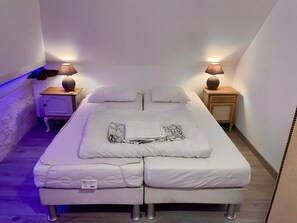 Una habitación pequeña con una cama individual, dos mesitas de noche y dos lámparas.