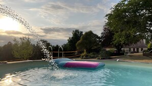 Ein Schwimmbecken mit einer schwimmenden Plattform und einem hölzernen Deck im Vordergrund.