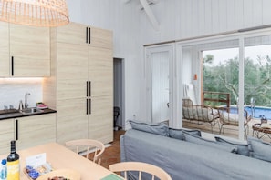 Una cocina moderna con gabinetes de madera y un comedor con sofá y sillas grises.