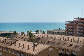A coastal residential area with terracotta-tiled rooftops, a beach, and a clear sky. - Apartment 'Beach' with Sea View, Wi-Fi and Air Conditioning (Alboraya)