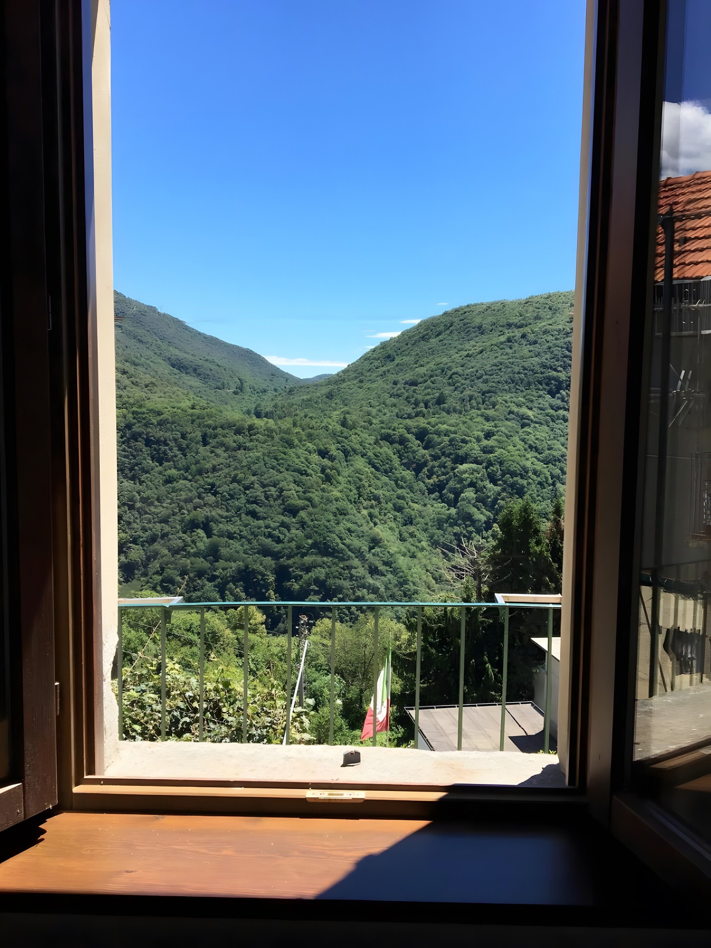 Ein Balkon mit freiem Blick auf ein üppiges, grünes Tal und Hügel.