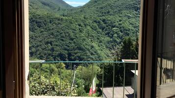 Ein Balkon mit freiem Blick auf ein üppiges, grünes Tal und Hügel.