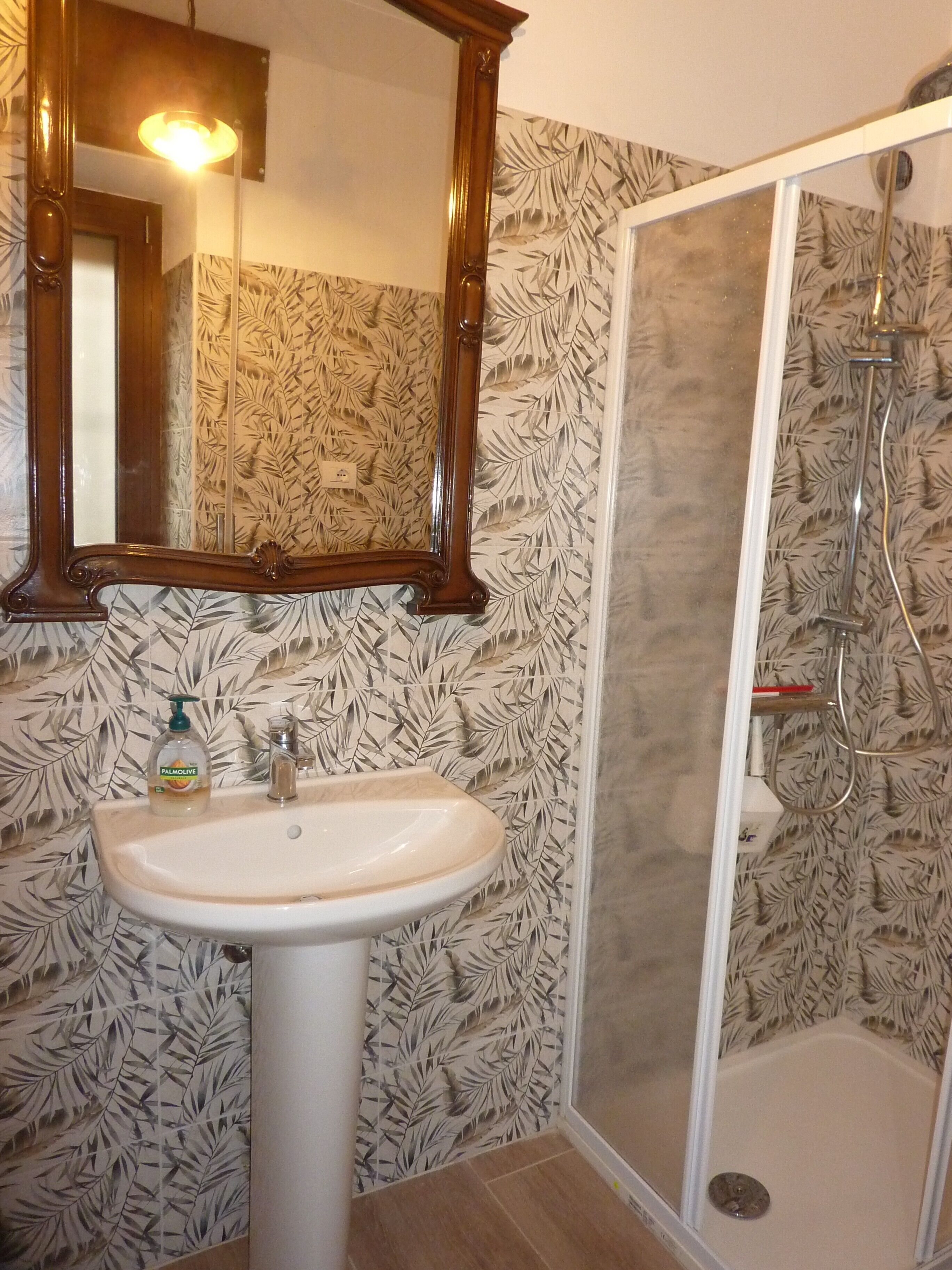 Ein Badezimmer mit Waschbecken, Spiegel und Dusche.