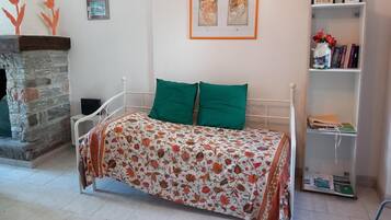 Ein Schlafzimmer mit einem Bett, einem Bücherregal und einem Kamin aus Stein.