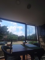 Una habitación con un ventanal grande, una mesa y sillas.