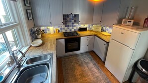 A kitchen with white cabinets, a wooden countertop, a sink, and a built-in oven. - Cottage - Sleeps 5 - Parking & Wood Burning Stove (Alnwick)