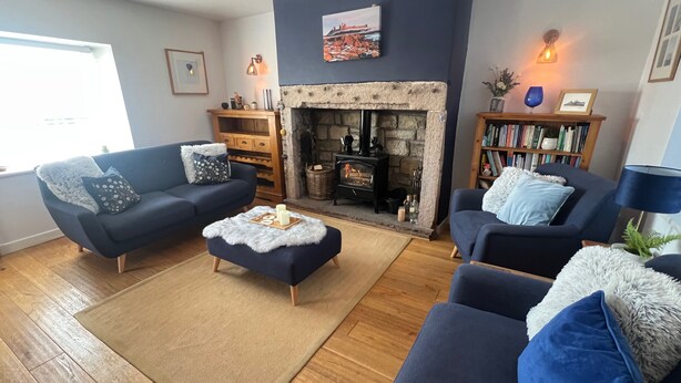 A cozy living room with a fireplace, two sofas, a coffee table, and a bookshelf. - Cottage - Sleeps 5 - Parking & Wood Burning Stove (Alnwick)