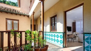 A courtyard with potted plants, a tiled floor, and a view of the interior. - Genteel Home Santa Ines (Granada)
