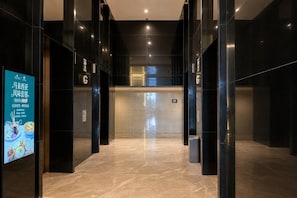 A modern elevator lobby with reflective black walls and a marble floor. - Platinum Suites KLCC by Moonlight (Kuala Lumpur)