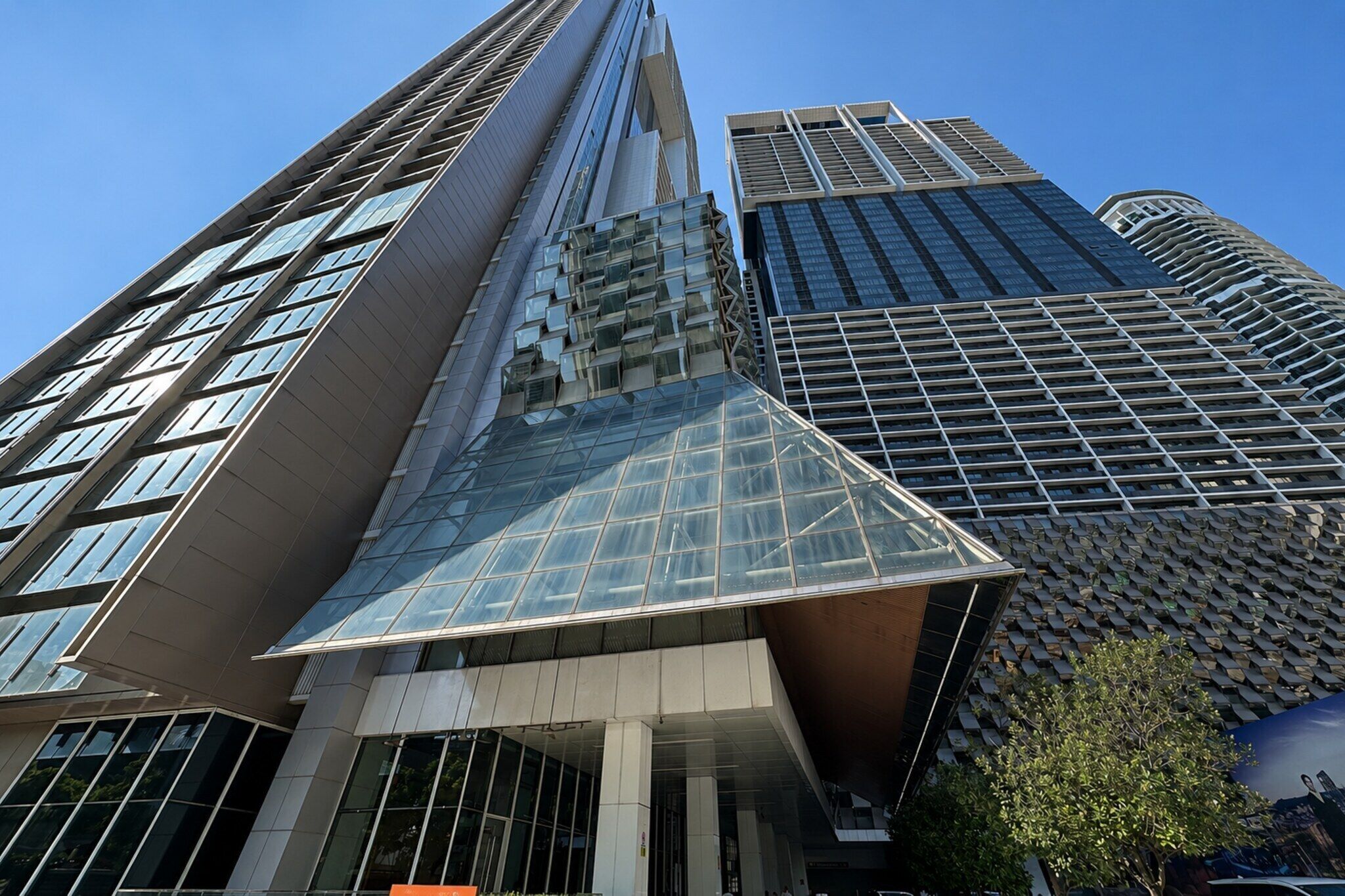 Um moderno edifício alto com um design angular característico e fachada de vidro refletante.