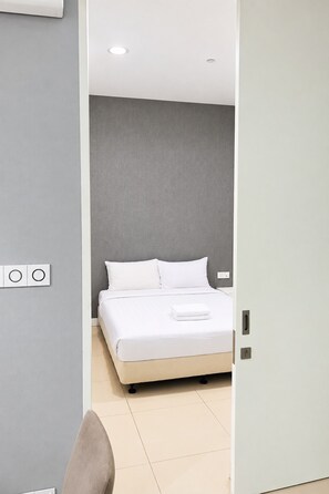 Quarto moderno com cama, porta e interruptor de luz na parede.