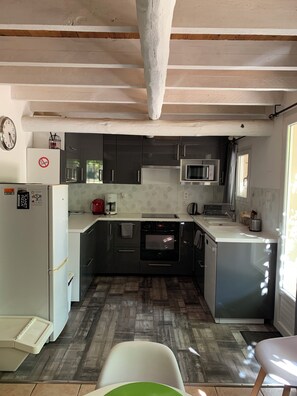 A compact kitchen with a refrigerator, microwave, oven, and a coffee maker. - Cottage in the Vineyards (Roquemaure)