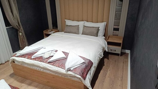 Un lit bien fait, avec des oreillers et des serviettes pliées posées sur le dessus.