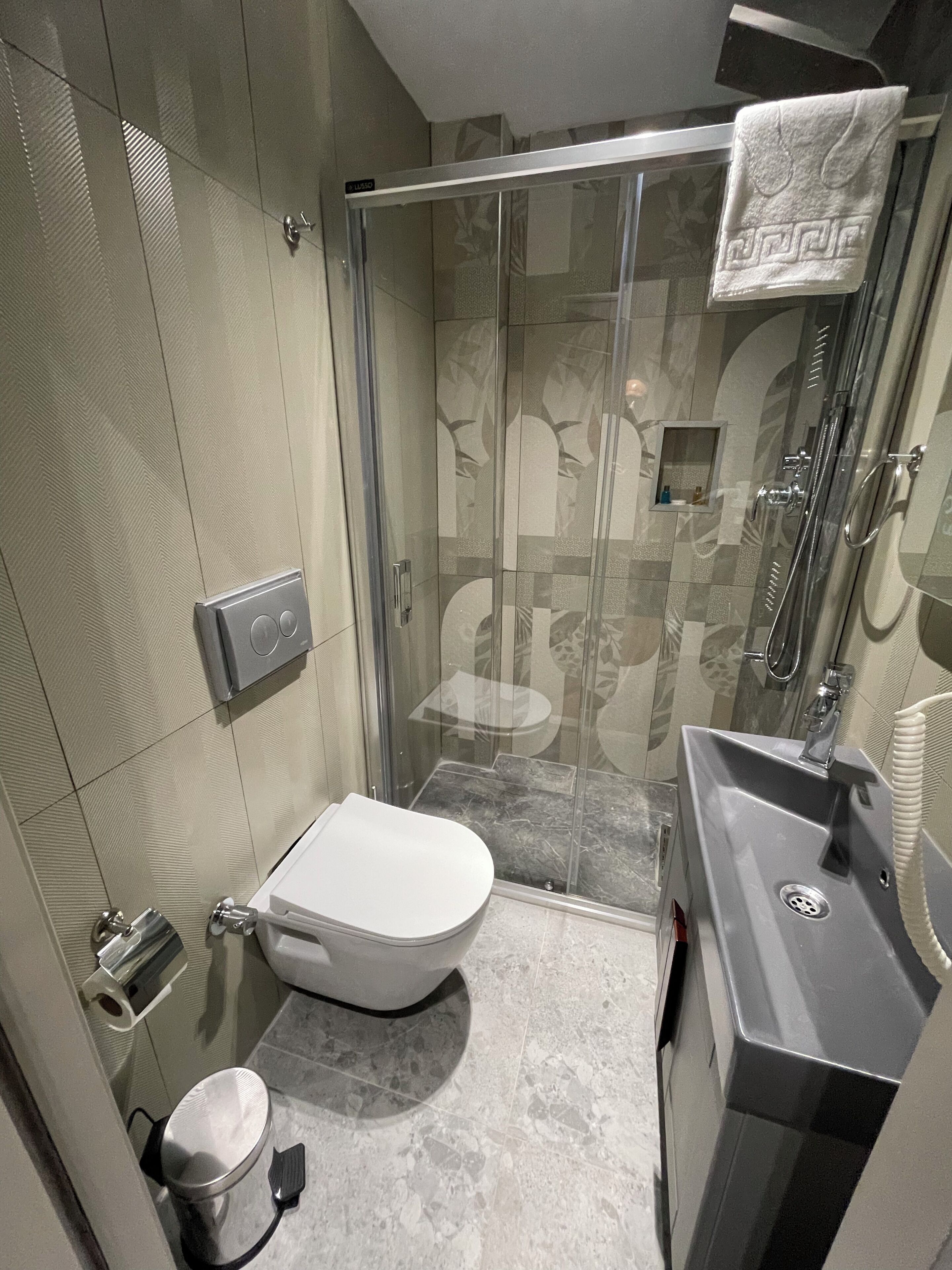 Ein modernes Badezimmer mit einer Duschkabine aus Glas, einer Toilette und einem Waschbecken.