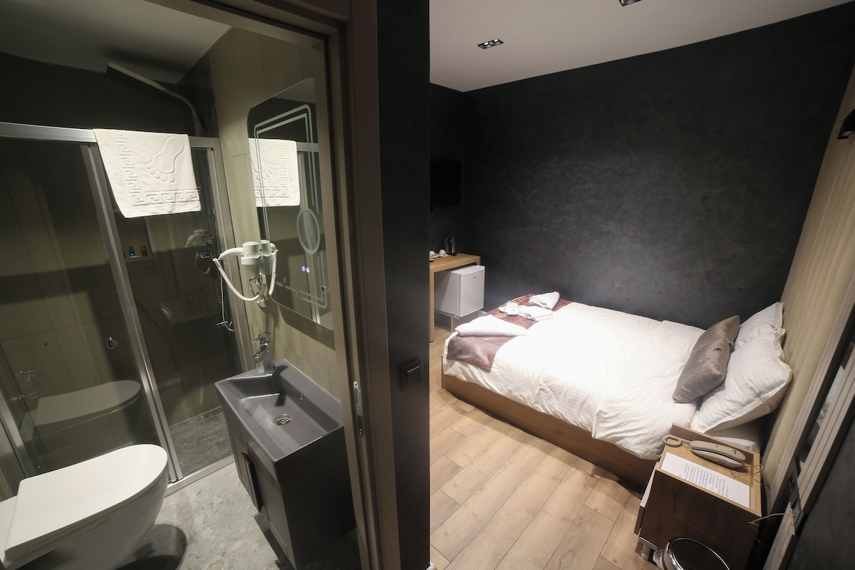 A bathroom with a glass-enclosed shower, a toilet, and a sink.