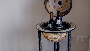 Una mesa de estilo antiguo con una cubierta esferográfica, dos botellas, una botella de plata y un recipiente metálico.