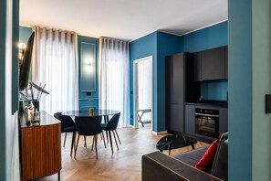 A modern living space with a dining area, kitchen, and seating area. - VivimiHome Suite Casa Degli Specchi (Milano)