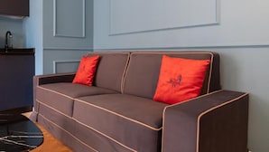 Deluxe-Apartment, Balkon, Stadtblick | Wohnbereich | 50-Zoll-Smart-TV mit Kabelempfang