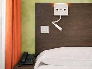 A hotel room with a bed, a bedside telephone, a power outlet, and a wall-mounted charging station. - Studio Apartment Adapted for People with Limited Mobility · Retiro (Madrid)