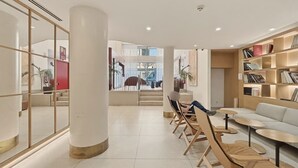 Un intérieur moderne avec une colonne centrale, un espace salon et une bibliothèque.