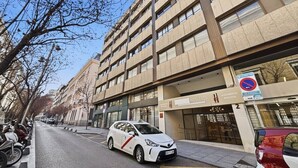 Un immeuble à plusieurs étages, avec des locaux commerciaux au rez-de-chaussée et des logements aux étages supérieurs.