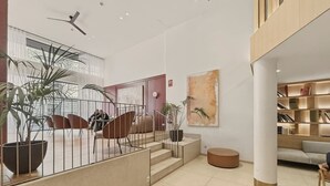 Un intérieur moderne avec un escalier, un coin salon et une bibliothèque.